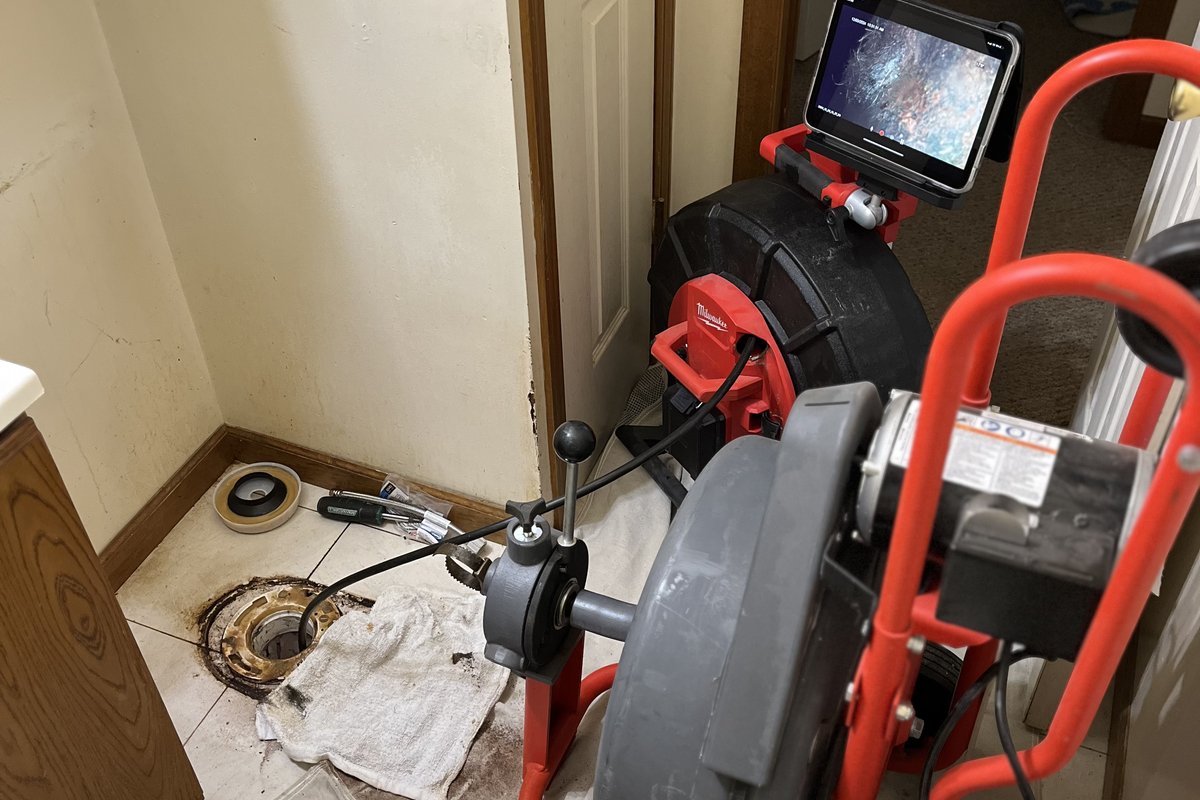 Alliance Plumbing technician clearing a clogged drain in Kalamazoo basement